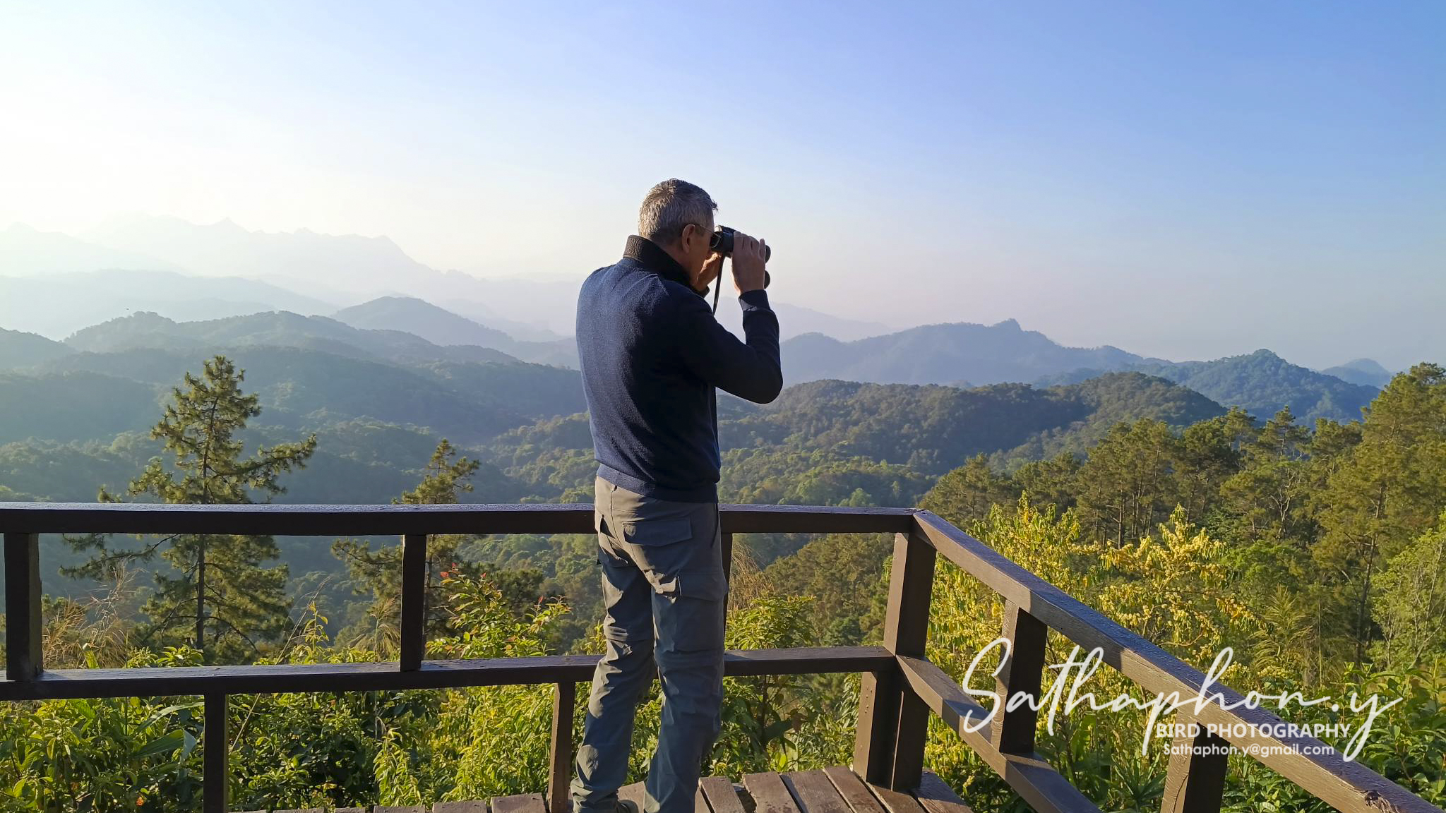 Birdwatcher using binoculars at scenic viewpoint in Chiang Dao, Northern Thailand